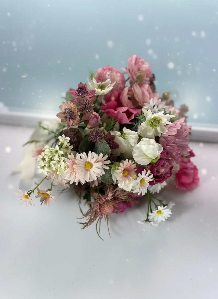 Close-up of a traditional half-casket spray featuring vibrant red roses and white carnations, centered beautifully on a dark wood casket.